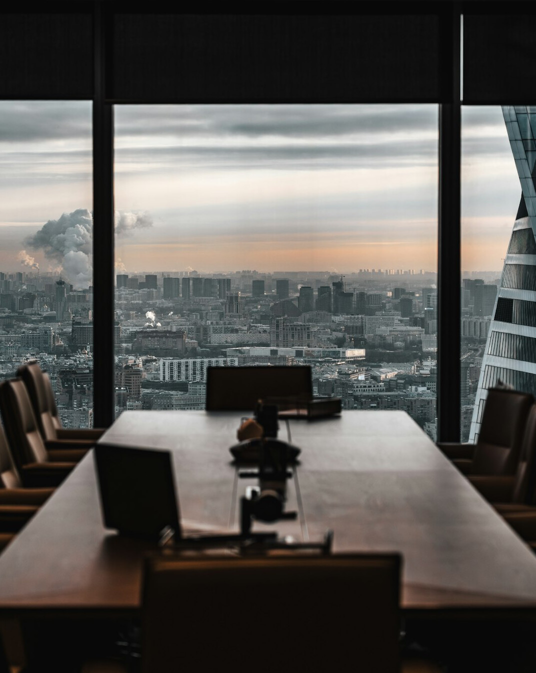 Empty modern boardroom with long table and chairs